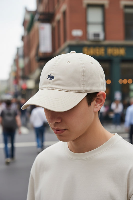 A purple baseball cap with an embroidered fox design held in someone's hand.