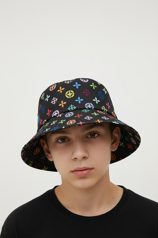 Black bucket hat with colorful patterns on a stand next to a plant and vase.