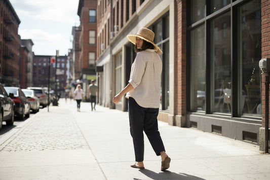 Woven straw hat with a tassel on a wooden surface