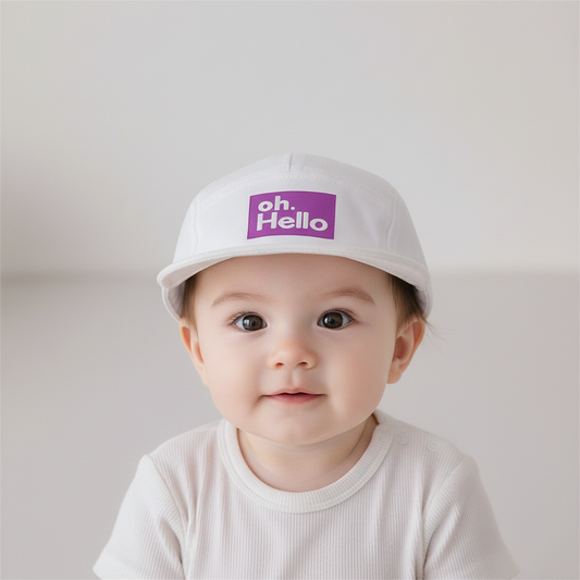 A collection of children's baseball caps in various colors, each featuring a brim with the text 'oh hello' on a white label.