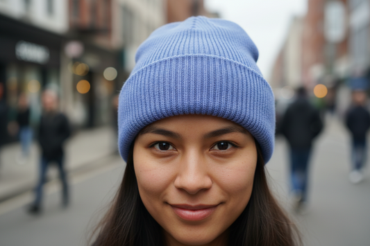 A collection of knitted hats in various solid colors including black, blue, beige, orange, red, purple, and gray.