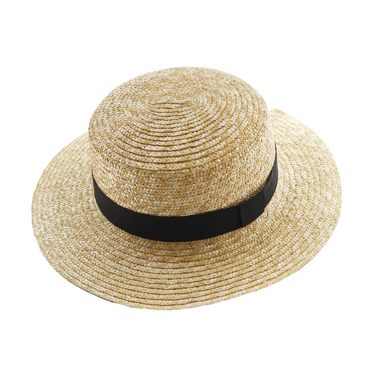 Straw hat with a black band on a white surface