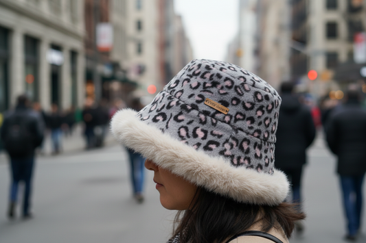 Gray leopard print beanie with fur trim on a white background