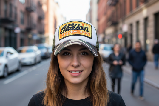 A green and brown camouflage baseball cap with a mesh back and a logo on the front.