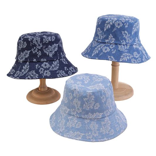 Three floral-patterned bucket hats on wooden stands against a neutral background