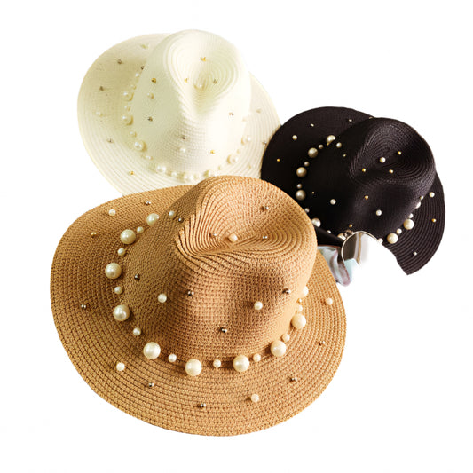 Three sun hats with pearl embellishments on a surface.